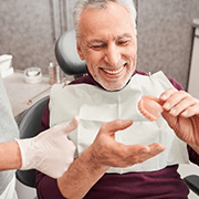 a patient smiling after getting his new dentures