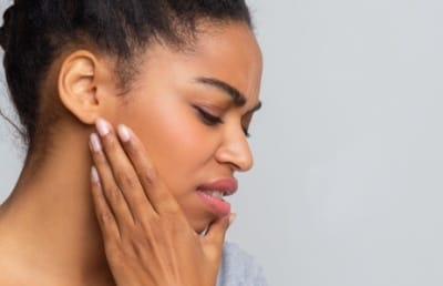 Woman with jaw pain holding her cheek