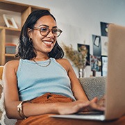 Woman smiling while working on laptop at home