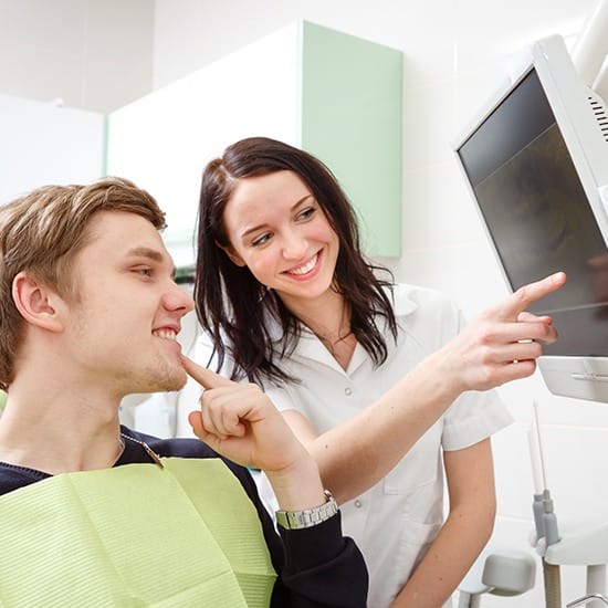 Dentist and dental patient looking at dental x-rays