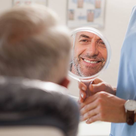 Man looking at smile after cerec one visit dental restoration