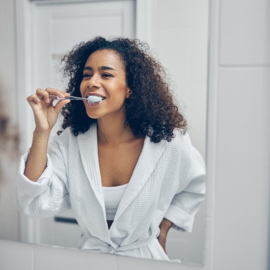 Patient in Fairfax brushing their teeth before a dental checkup