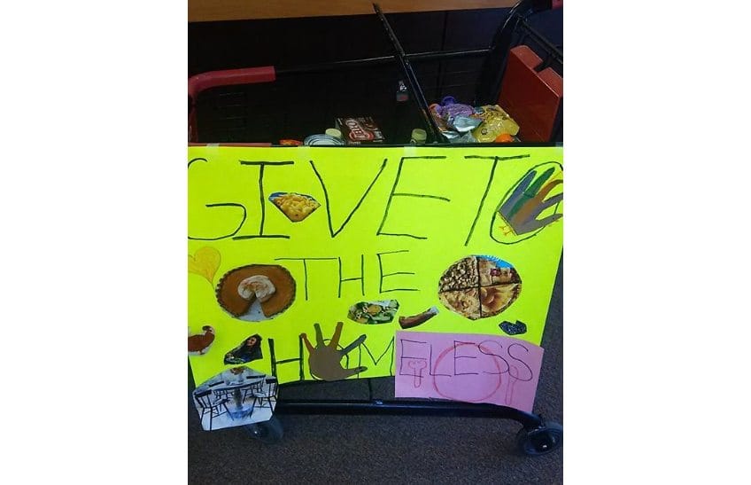 Give to the homeless sign at food drive event