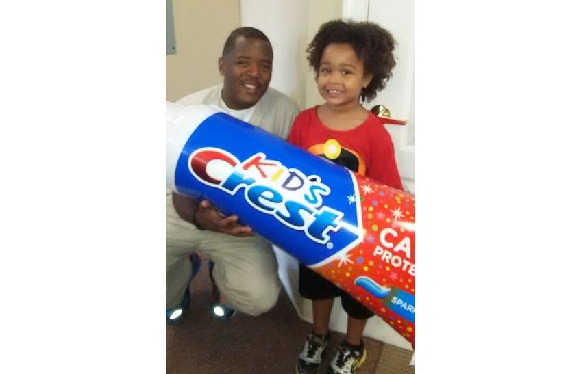 Doctor Murray and child holding a giant tube of toothpaste