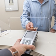 A man paying the cost of dental crowns