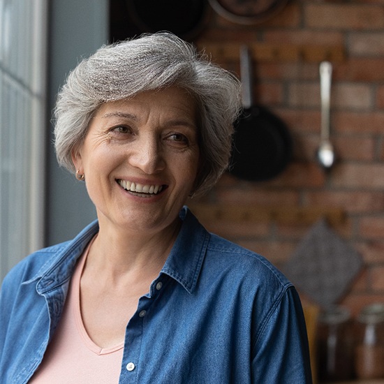 patient smiling after getting dentures in Fairfax