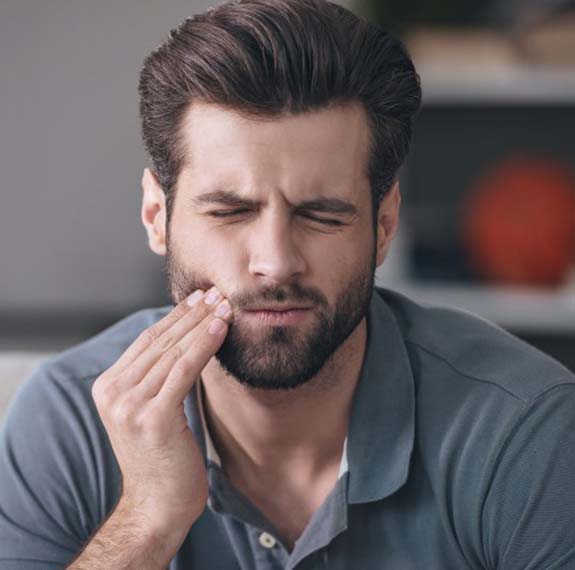 Man with a toothache in Fairfax holding his cheek