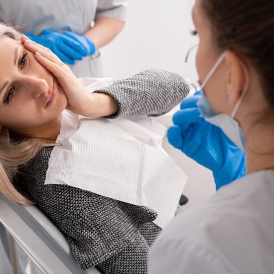 Lady with oral pain looks to dentist