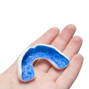 person holding a blue mouthguard in their hand