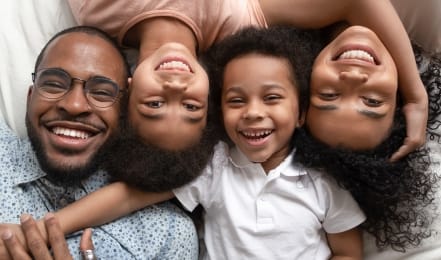 Laughing family of four laying down