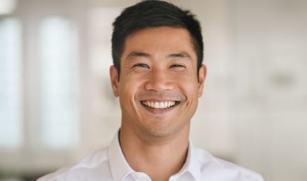 Man in white collared shirt grinning
