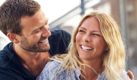 Man and woman laughing outdoors