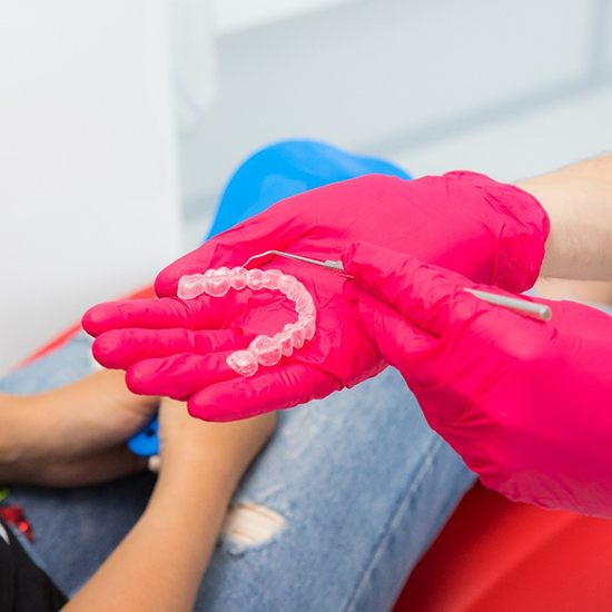 Dentist pointing to Invisalign tray with patient