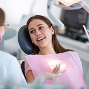 Woman smiling at dentist while sitting in treatment chair