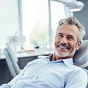 Senior man smiling while sitting in dental chair