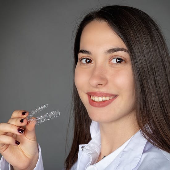 Woman holding an invisalign tray