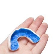 blue mouthguard in a person’s hand