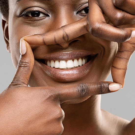 Smiling woman framing her smile after root canal in Fairfax