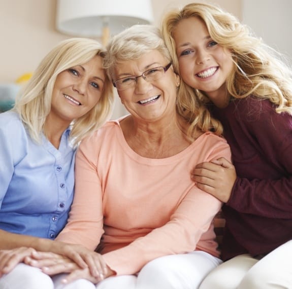 Three generations of women sharing healthy smiles after receiving dental services in Fairfax