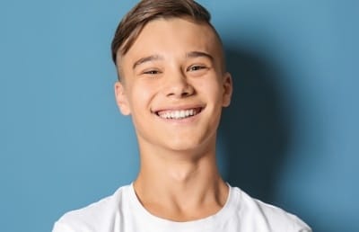 Teen boy with straight smile after orthodontic treatment