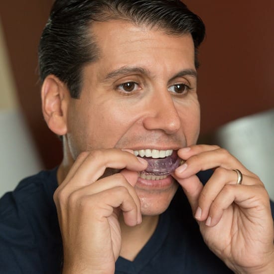 Man placing sleep apnea oral appliance