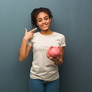 woman with piggy bank pointing to her smile 