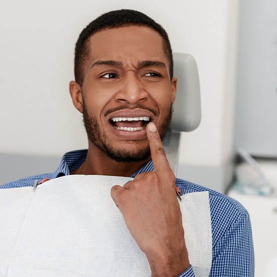 Man pointing to smile before wisdom tooth extraction