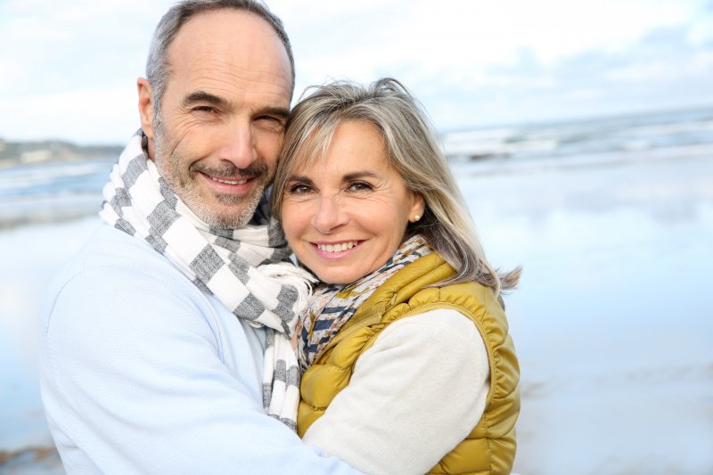 Mature couple smiling on beach together