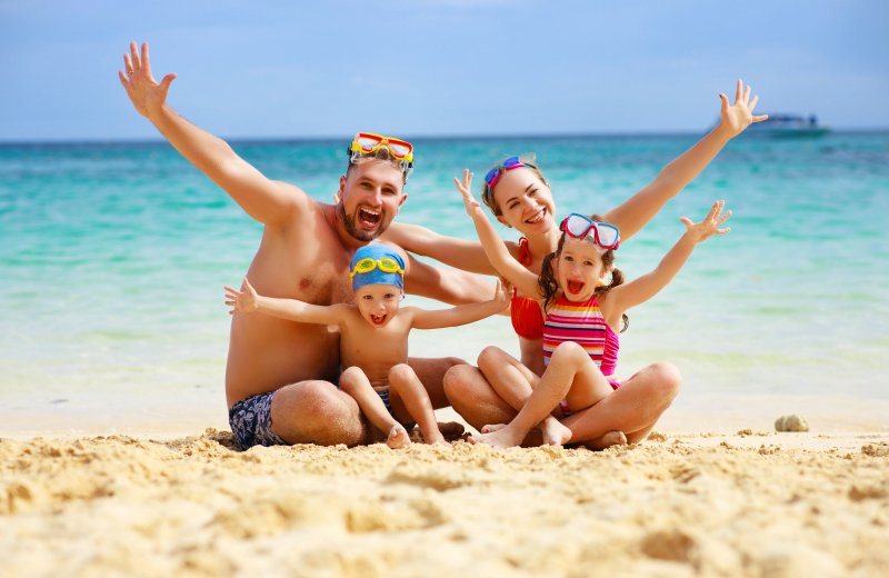 family posing on the beach during summer vacation