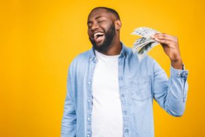 man holding the money he saved by maximizing dental insurance benefits 