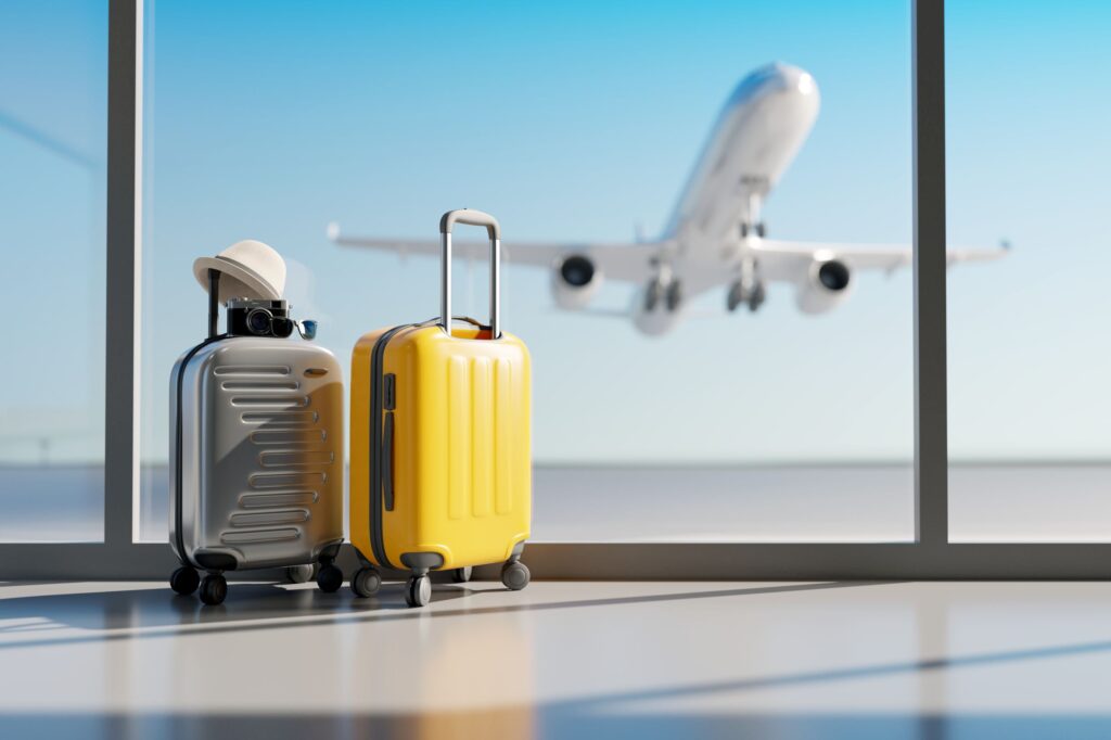 Two suitcases in airport with plane taking off in background